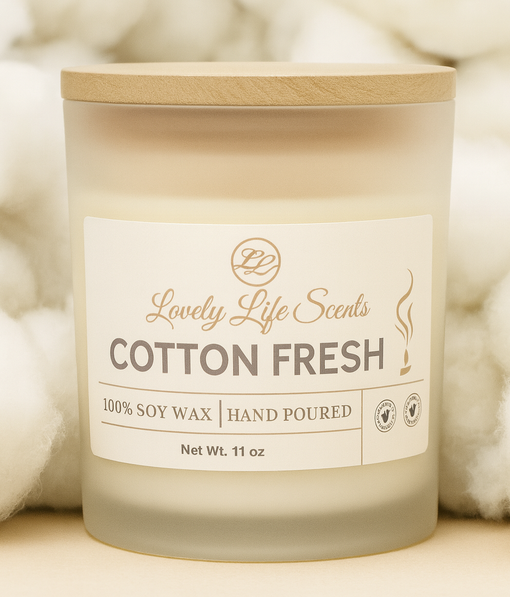 Candle labeled 'Cotton Fresh' by 'Lovely Life Scents' with a wooden lid on a cotton background.